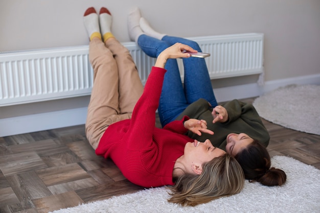 Foto mujeres de tiro completo tomando selfie en el piso