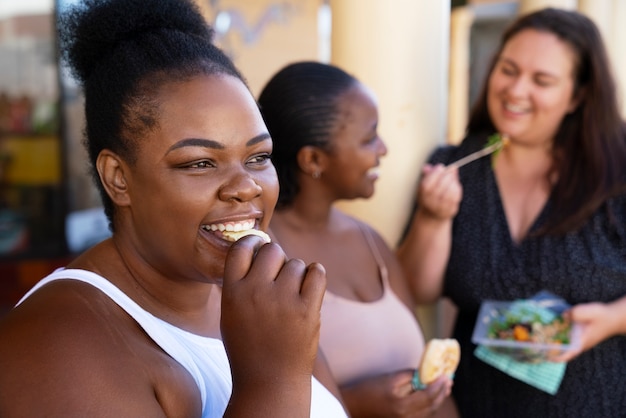 Mujeres de tiro medio con comida deliciosa