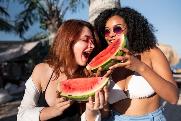 Mujeres de tiro medio comiendo sandía