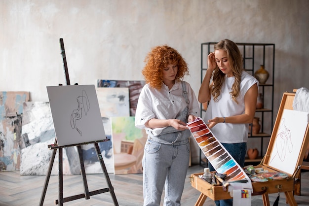 Foto mujeres de tiro medio que eligen el color de la pintura