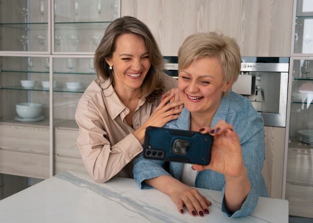 Foto mujeres de tiro medio con smartphone