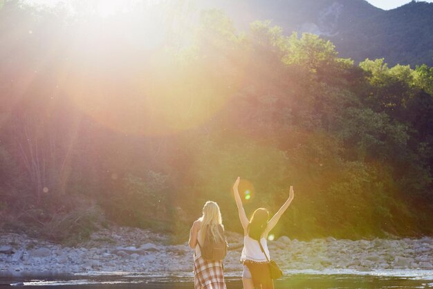 Mujeres tomando un descanso durante un viaje de senderismo y celebrando Mujeres despreocupadas celebrando juntas durante un viaje de senderismo a las montañas Amigos despreocupados tomando un descanso durante una caminata para celebrar