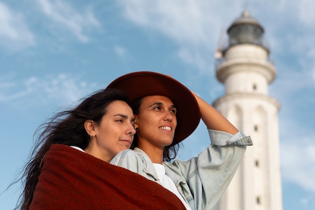 Mujeres de tomas medias posando con un faro