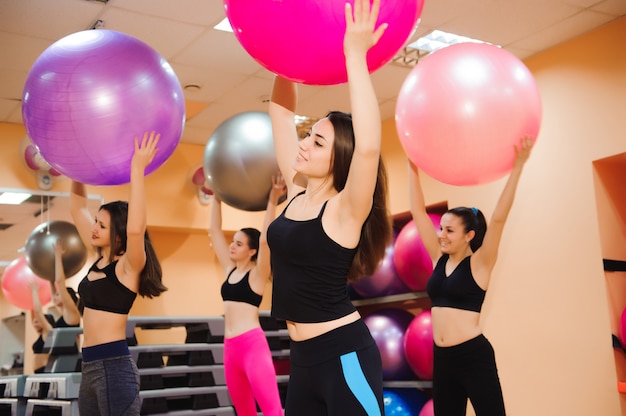 Mujeres trabajando con pelota de ejercicios en el gimnasio