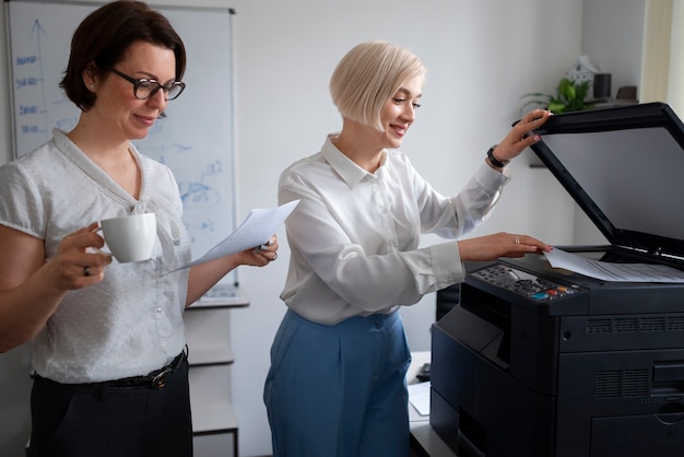 Mujeres en el trabajo en la oficina usando impresora