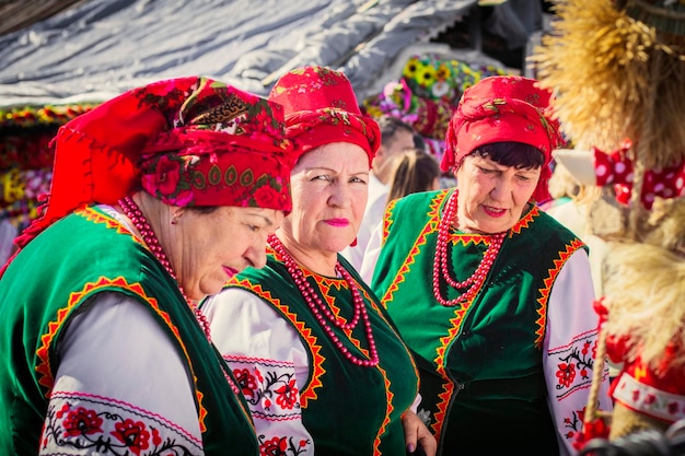 Mujeres ucranianas vestidas con ropa tradicional ucraniana con chales rojos y cuentas en el mercado