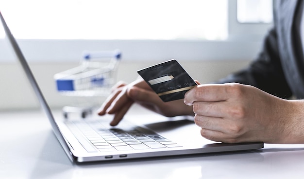 Las mujeres usan la computadora portátil para registrar compras en línea usando pagos con tarjeta de crédito