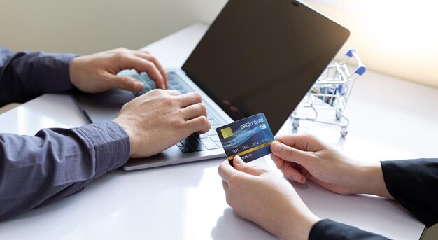 Foto las mujeres usan la computadora portátil para registrar compras en línea usando pagos con tarjeta de crédito