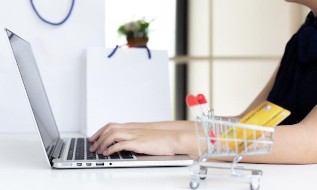 Las mujeres usan la computadora portátil para registrar compras en línea usando pagos con tarjeta de crédito