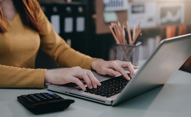 Las mujeres usan computadoras portátiles para pagos de computadoras portátiles, compras en línea, omnicanales, sentadas en escritorios