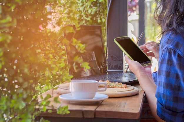 Las mujeres usan teléfonos inteligentes en coffeeshop