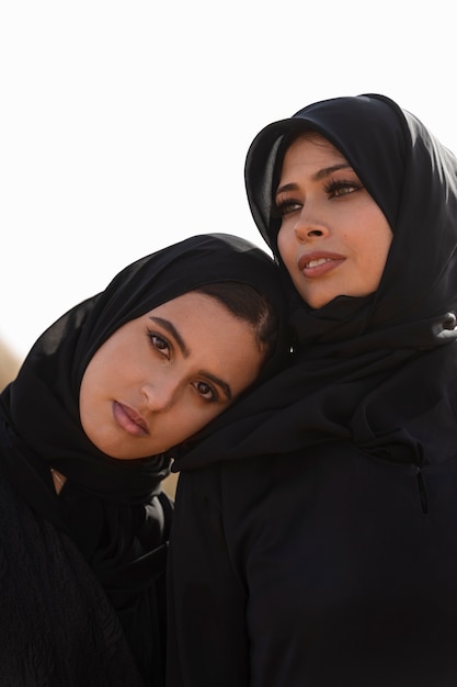 Foto mujeres vestidas con hijab en el desierto