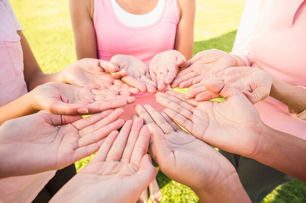 Mujeres vestidas de rosa para el cáncer de mama y mostrando las manos