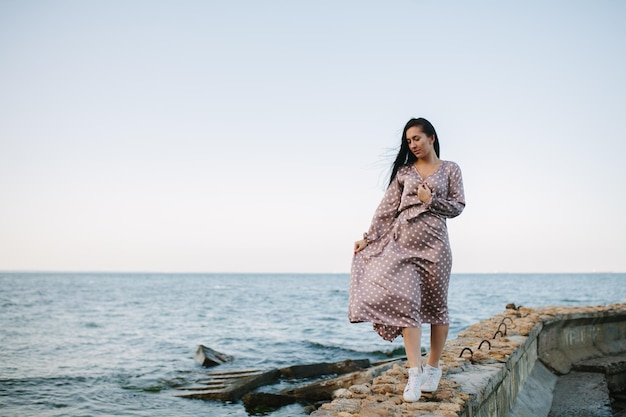 Mujeres en un vestido de verano en la arena de la playa cerca del océano