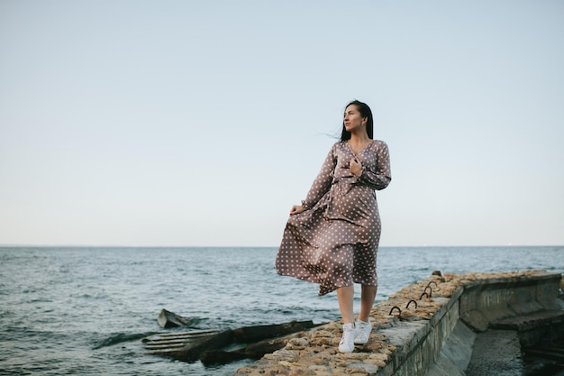 Mujeres en un vestido de verano en la arena de la playa cerca del océano