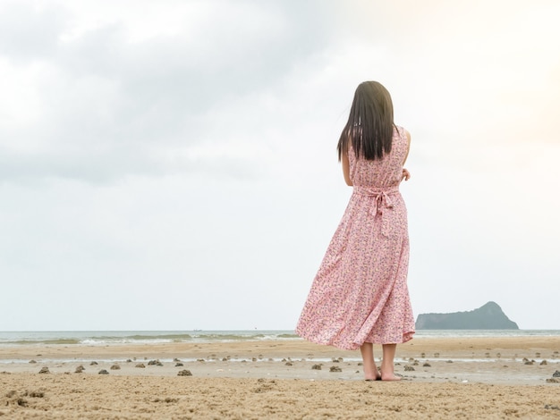 Mujeres en vestidos rosados, Stand alone on the beach.