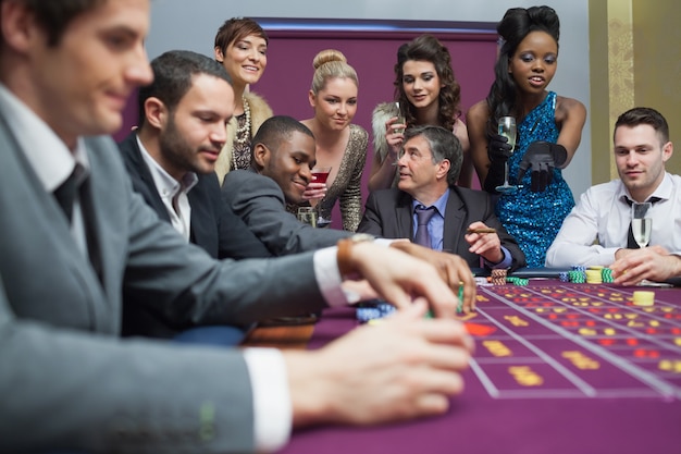 Foto mujeres viendo a los hombres jugar a la ruleta