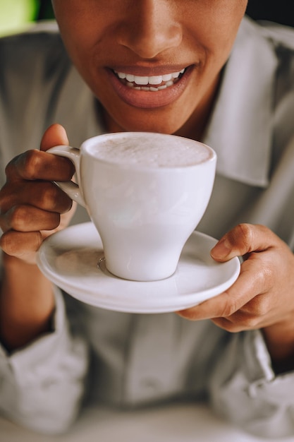 Mulata muito sorridente a tomar café e a sentir-se bem