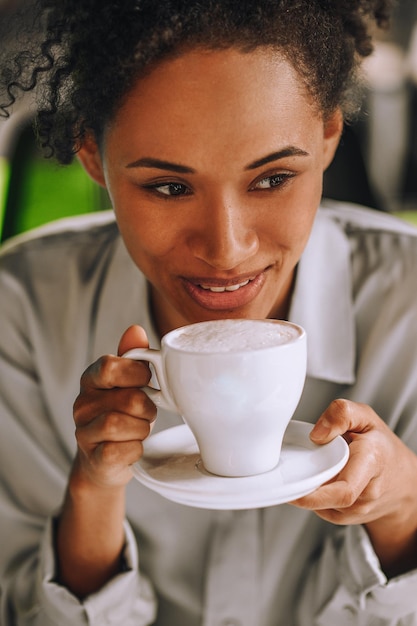 Mulata muito sorridente a tomar café e a sentir-se bem