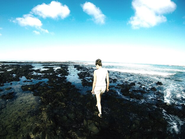 Foto mulher a caminhar na praia