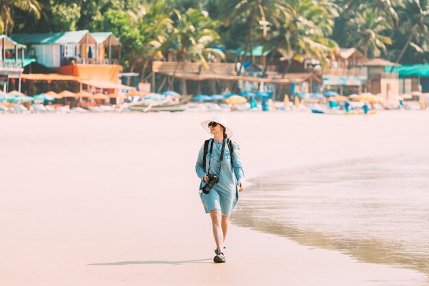 Foto mulher a caminhar pela praia.