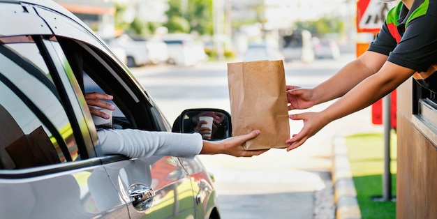 Foto mulher a comer fast food no drivethru.