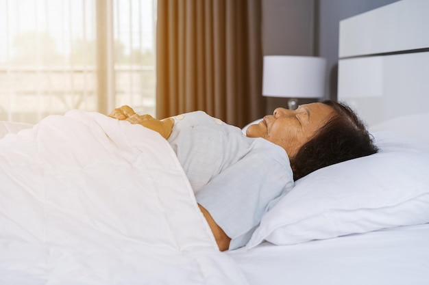 Mulher a dormir na cama em casa.