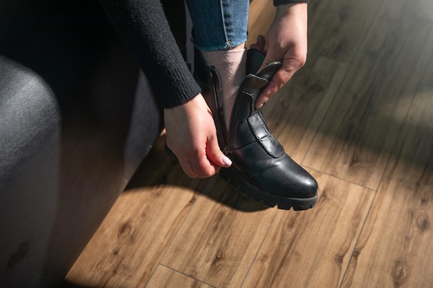 Mulher a experimentar botas de inverno em casa