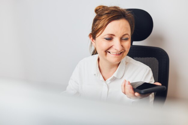 Mulher a falar ao telefone usando o modo de alto-falante Mulher a gravar mensagem de áudio usando assistência de voz
