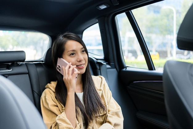 Mulher a falar ao telemóvel e a sentar-se no carro.