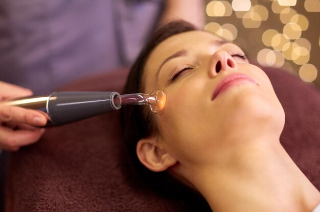 Foto mulher a fazer um tratamento facial hidradérmico num spa.