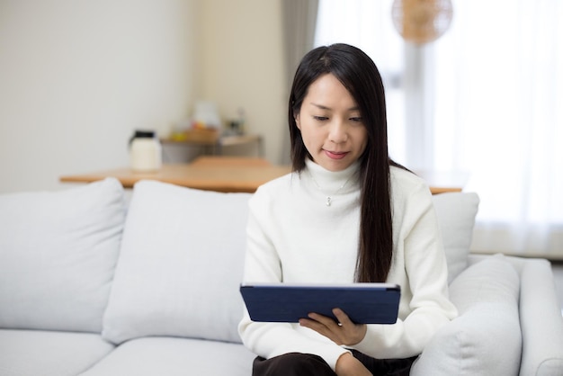 Mulher a ler num tablet digital em casa