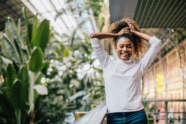 Mulher à moda nova que prende seu cabelo afro crespo.