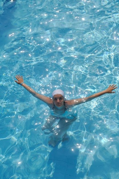 Mulher a relaxar na piscina.