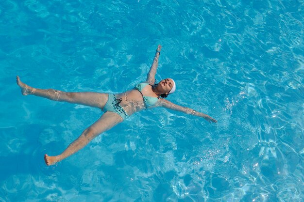 Mulher a relaxar na piscina.