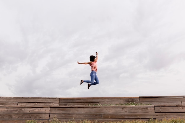 Foto mulher a saltar ao ar livre contra o céu