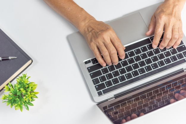 Mulher a trabalhar e a digitar no teclado na mesa em casa.