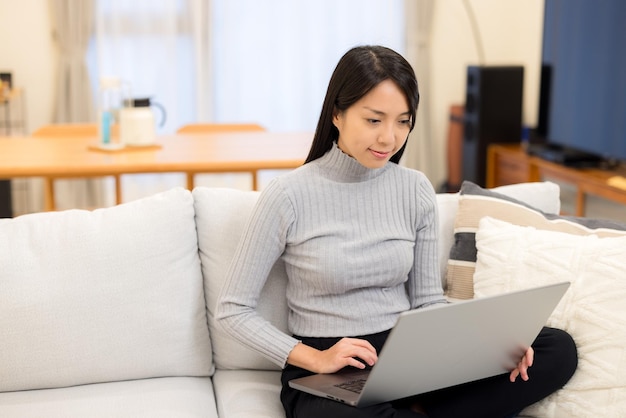 Mulher a trabalhar em computador portátil em casa