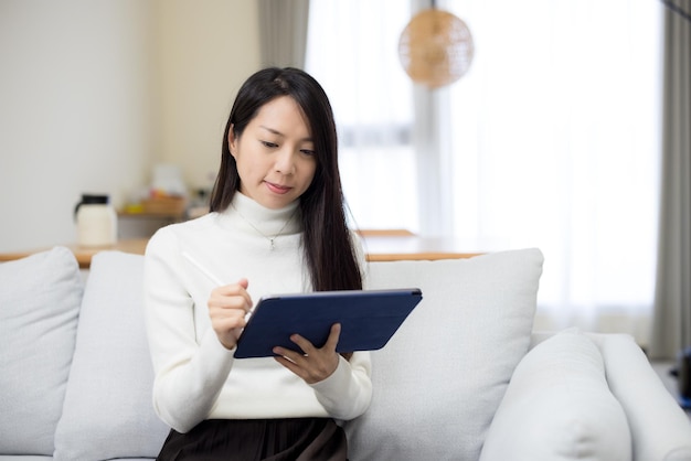 Mulher a usar tablet em casa