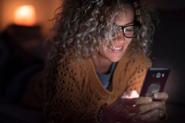 Foto mulher a usar telemóvel em casa