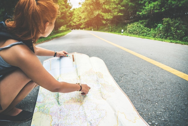 Foto mulher a verificar o mapa na estrada