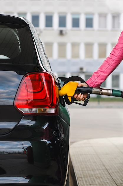 Foto mulher abastecendo o carro no posto de gasolina