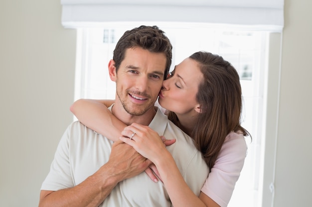 Mulher abraçando e beijando o homem por trás