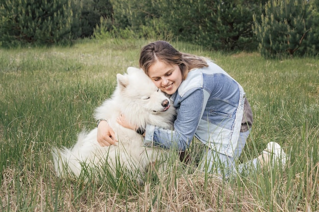 Mulher abraçando seu cachorro samoiedo