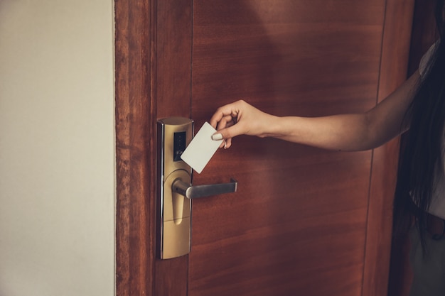 Mulher abrindo fechadura eletrônica de quarto de hotel com cartão-chave