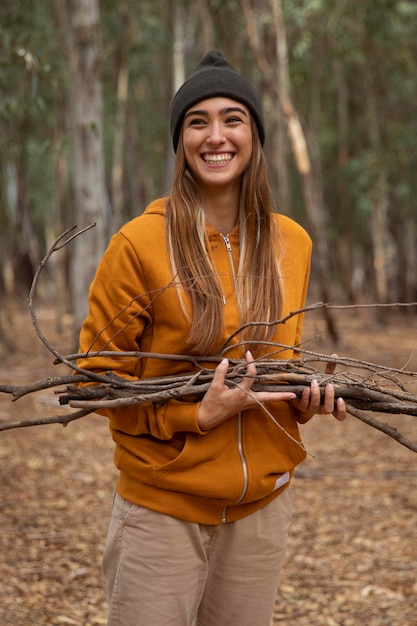 Foto mulher acampando e juntando lenha