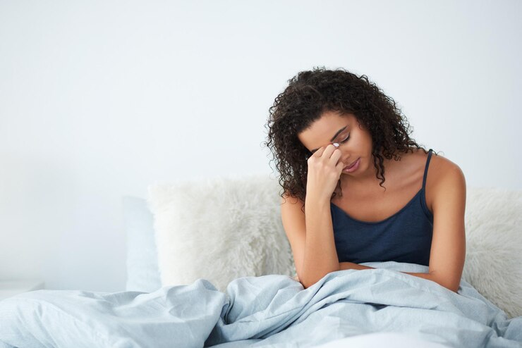 Foto mulher acordar e estresse no quarto com dor de cabeça medo ou frustrado por insônia ou fadiga mental pessoa africana massagem cabeça para dor anemia ou cansado de manhã com deficiência de ferro em casa