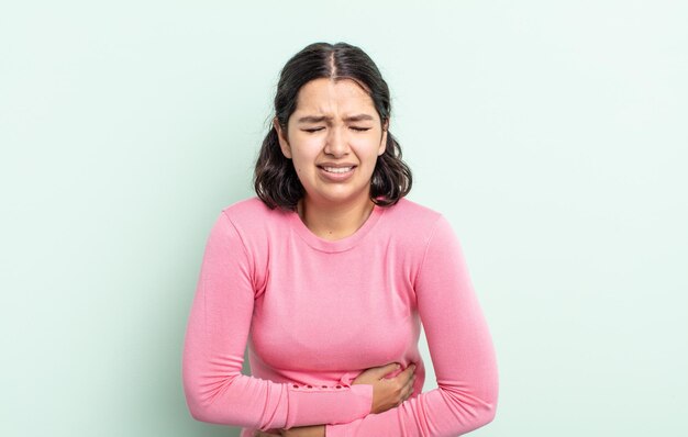 Mulher adolescente bonita se sentindo ansiosa, doente, doente e infeliz, com uma forte dor de estômago ou gripe