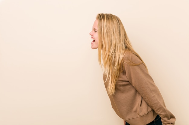 Mulher adolescente bonito e natural, gritando para um espaço de cópia