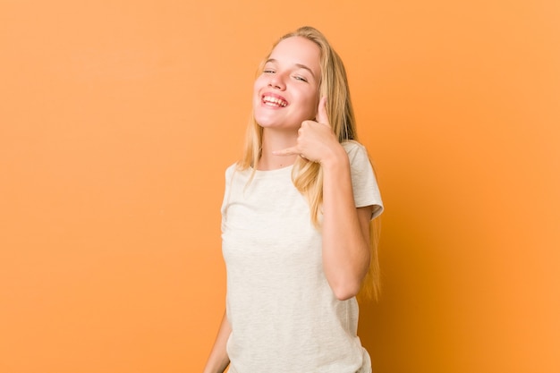 Mulher adolescente bonito e natural, mostrando um gesto de chamada de telefone móvel com os dedos.